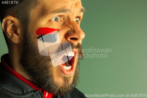 Image of Portrait of a man with the flag of the Germany painted on him face.