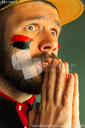 Image of Portrait of a man with the flag of the Germany painted on him face.