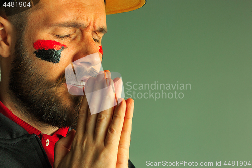 Image of Portrait of a man with the flag of the Germany painted on him face.