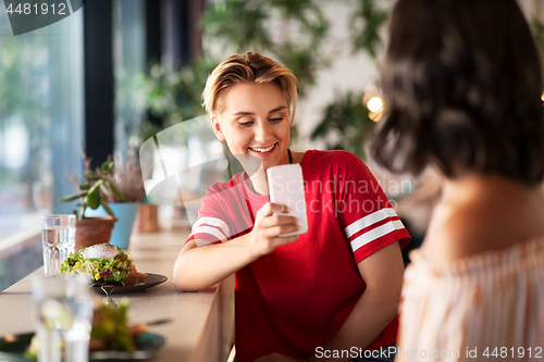 Image of women having lunch and photographing at cafe