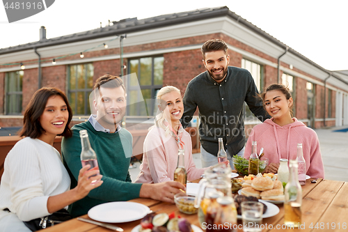 Image of happy friends with drinks or bbq party on rooftop
