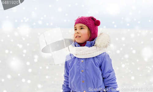 Image of happy little girl in winter clothes outdoors