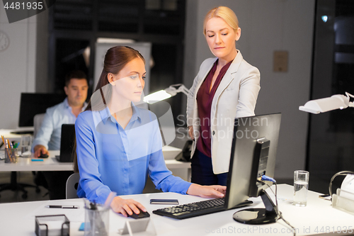 Image of businesswomen with computer working late at office