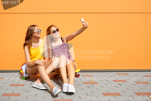 Image of teenage girls with skateboards taking selfie