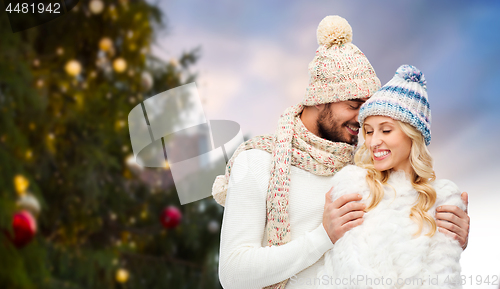 Image of happy couple hugging over christmas tree