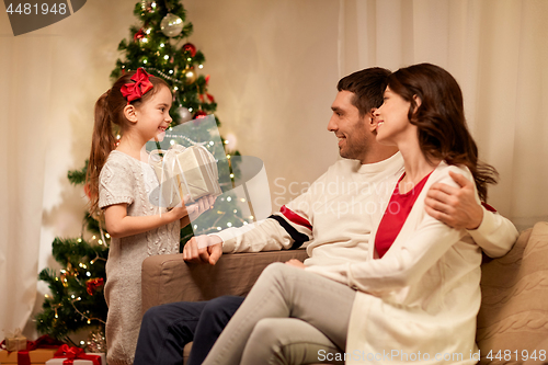 Image of happy family with christmas present at home