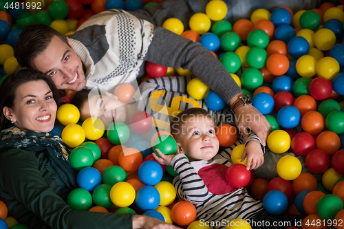 Image of young parents with kids in a children\'s playroom