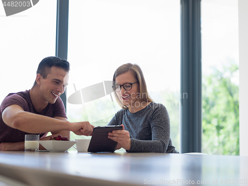 Image of couple enjoying morning coffee and strawberries