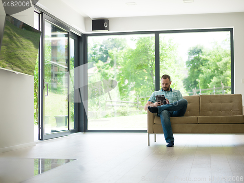 Image of man on sofa using tablet computer