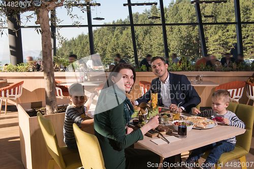 Image of Young parents enjoying lunch time with their children