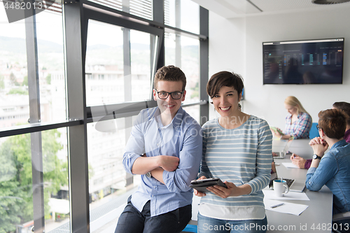 Image of Two Business People Working With Tablet in office