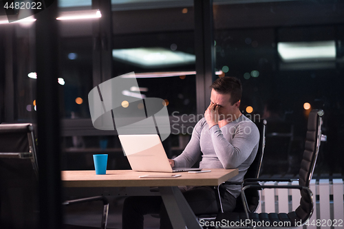 Image of man working on laptop in dark office