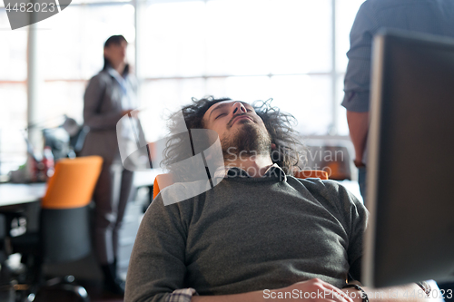 Image of young businessman relaxing at the desk