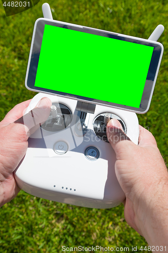 Image of Hands Holding Drone Quadcopter Controller With Blank Green Scree