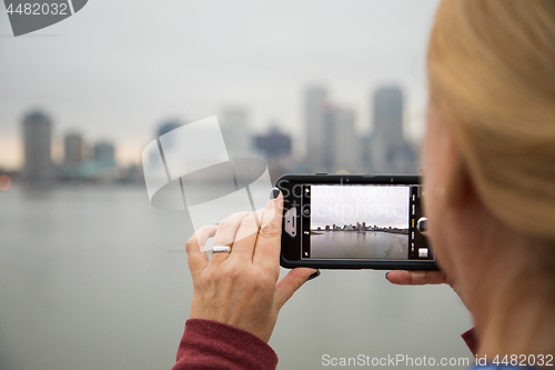 Image of Woman Taking Pictures of The New Orleans Skyline with Her Smart 