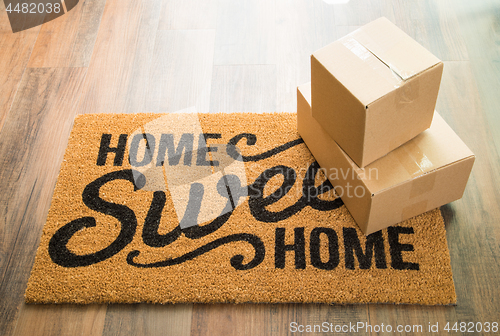 Image of Home Sweet Home Welcome Mat On Wood Floor With Boxes