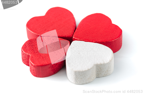 Image of Three red and one white wooden hearts isolated on white