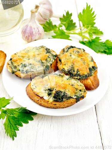 Image of Sandwich of nettle and cheese in plate on light board