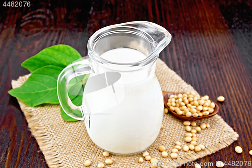 Image of Milk soy in jug with beans on wooden board