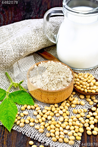 Image of Flour soy in bowl with soybeans and milk on wooden board