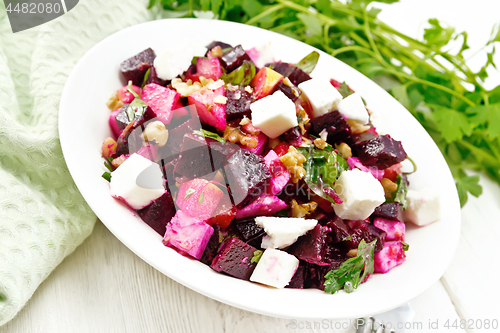 Image of Salad with beetroot and apple in plate on light board