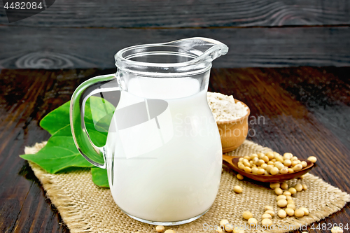 Image of Milk soy in jug with flour on dark board