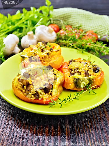 Image of Pepper stuffed with mushrooms and couscous in green plate on woo
