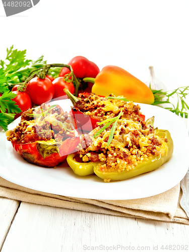 Image of Pepper stuffed with meat and couscous in white plate on light bo