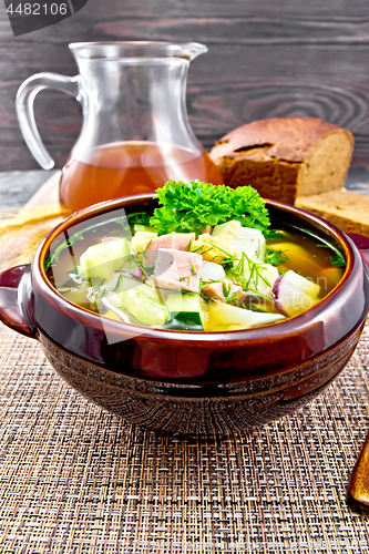 Image of Okroshka in clay bowl on brown napkin