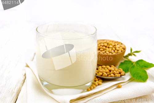 Image of Milk soy in glass with leaf on board