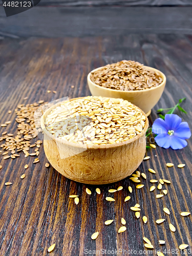 Image of Flaxen white and brown seed in bowl with flower on dark board