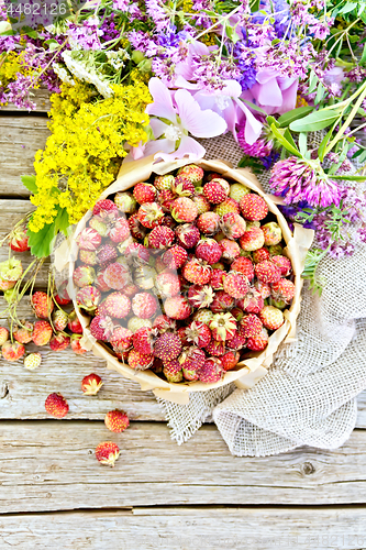 Image of Strawberries in box with flowers on board top