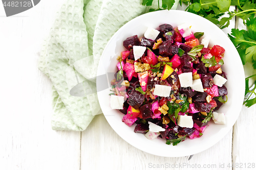 Image of Salad with beetroot and feta in plate on board top