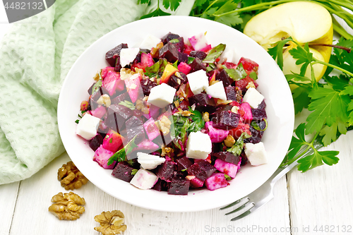 Image of Salad with beetroot and walnuts in plate on board