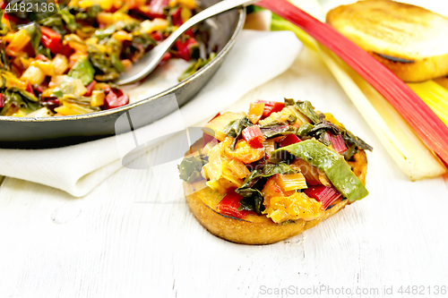 Image of Bruschetta with chard and orange on board