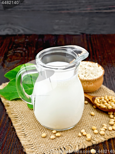 Image of Milk soy in jug with flour and leaf on board