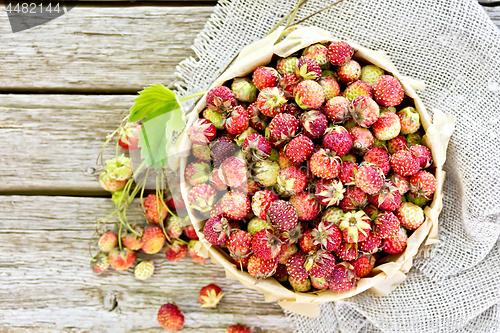 Image of Strawberries in box on old board top