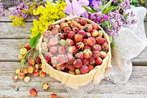Image of Strawberries in box with flowers on old board