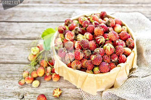 Image of Strawberries in box on wooden board