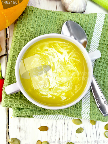 Image of Soup-puree pumpkin with cream in white bowl on napkin top
