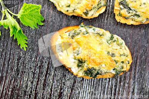 Image of Sandwich of nettle and cheese on dark board top