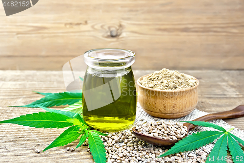 Image of Oil hemp in jar with flour in bowl on wooden board