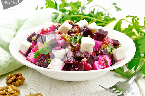 Image of Salad with beetroot and apple in plate on board