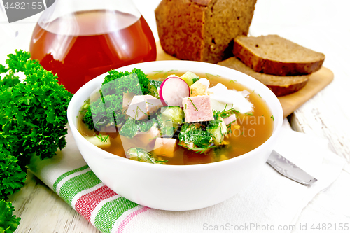 Image of Okroshka in white bowl on light wooden board