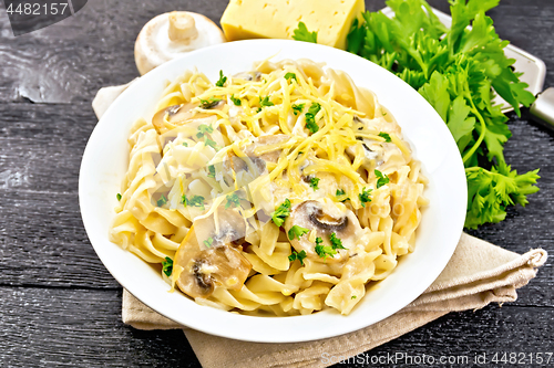 Image of Fusilli with mushrooms in plate on black board
