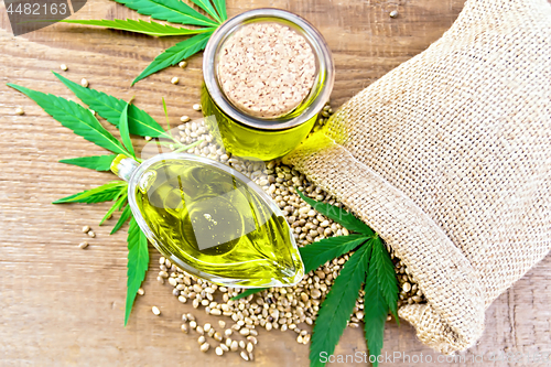 Image of Oil hemp in sauceboat and jar on board top