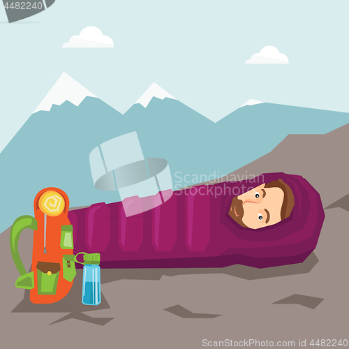 Image of Man sleeping in sleeping bag in the mountains.