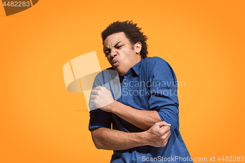 Image of Let me think. Doubtful pensive man with thoughtful expression making choice against orange background