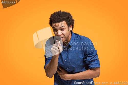 Image of The happy business man point you and want you, half length closeup portrait on orange background.