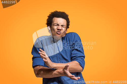 Image of Let me think. Doubtful pensive man with thoughtful expression making choice against orange background